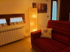 拉奎拉Come a casa的客厅配有红色的沙发和灯具