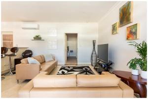 珀斯Charming, Cosy, Classic Executive 1 Bedroom Apartment的客厅配有沙发和桌子