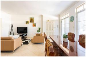 珀斯Charming, Cosy, Classic Executive 1 Bedroom Apartment的客厅配有桌椅和电视。