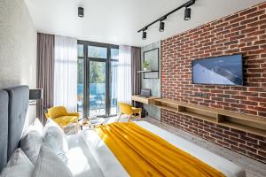 布克维Wood Hotel Resort & SPA的一间卧室设有砖墙和一张带电视的床。
