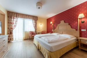 奥贝雷根欧贝里君酒店的一间卧室设有一张大床和红色的墙壁