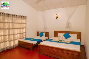 达瓦拉维Nil Bawana Nature Resort的一间卧室设有两张床和窗户。