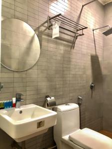 斯里曼绒双喜酒店的一间带水槽、卫生间和镜子的浴室