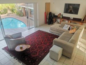 ClausthalVilla Incognito的带沙发和椅子的客厅以及游泳池。