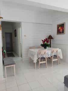 Kampong Bukit DaratHanizz Vacation Home的一张带椅子的白色桌子和花瓶