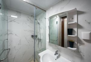 深圳WSSU 微宿精品公寓-深圳大学城塘朗地铁站店的带淋浴、盥洗盆和镜子的浴室