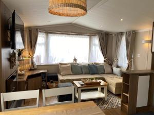 浦耳Cosy, coastal themed Holiday Home, Rockley Park, Poole, Dorset的客厅配有沙发和桌子