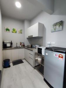 哥打京那巴鲁SabahSuite@Jesselton Quay的厨房配有白色橱柜和冰箱。