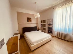 阿拉西奥Residence Conchiglia Aparthotel的卧室配有白色的床,铺有木地板
