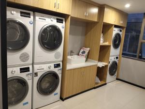 广州柏高酒店(广州塔大塘地铁站店）的洗衣房配有3台洗衣机和水槽