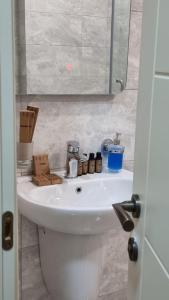 巴统GG ApartHotel的浴室设有白色水槽和盒子