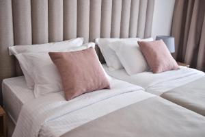 蒂瓦特Magnolia Place的两张带白色和粉红色枕头的床