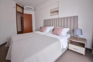 蒂瓦特Magnolia Place的卧室配有带粉红色枕头的大型白色床