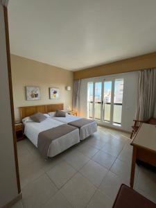 甘迪亚信天翁酒店的一间卧室设有一张大床和一个大窗户