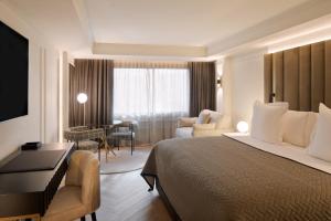 莱塞斯卡尔德-恩戈尔达Hotel MIM Andorra的酒店客房,配有一张床、一张桌子和椅子