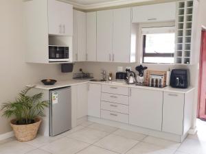 比勒陀利亚Studio's@360onChurch的白色的厨房,配有白色的橱柜和植物