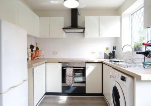 伯明翰Modern Spark Home with parking, garden, Wi-Fi的厨房配有白色橱柜和洗碗机。