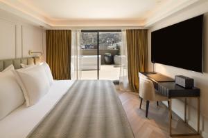 莱塞斯卡尔德-恩戈尔达Hotel MIM Andorra的酒店客房配有一张床、一张书桌和一台电视。