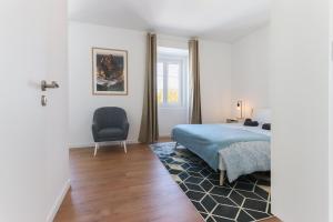 辛特拉Sintra Flower Lux Apartments的一间卧室配有一张床和一把椅子