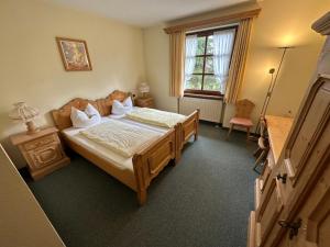 Neukirchen阿尔门劳什酒店的一间卧室配有一张床、一张桌子和一个窗户。