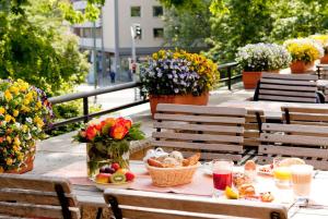 奥斯纳布吕克Vienna House by Wyndham Remarque Osnabrück的阳台上的野餐桌,摆放着食物和鲜花