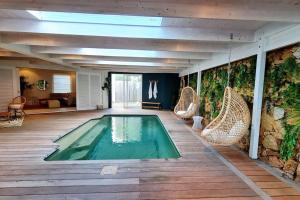 普利登堡湾Contemporary villa with amazing views的一个带藤椅的房间的游泳池