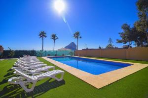 卡尔佩Villa Ambar - PlusHolidays的游泳池旁的一排白色躺椅