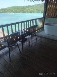 涛岛Koh Tao Relax Freedom Beach Resort的阳台配有两把椅子和一张桌子,享有海景。
