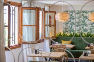科尔多瓦Soho Boutique Atalia的一间带桌子和绿色沙发的餐厅