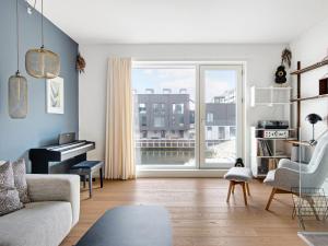 哥本哈根Sanders Pier - Fantastic 3-Bedroom Townhouse with Balcony Terrace的客厅配有钢琴和沙发
