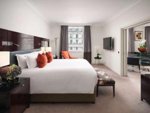 伦敦索菲特伦敦圣詹姆士酒店的酒店客房设有一张白色大床和一张书桌