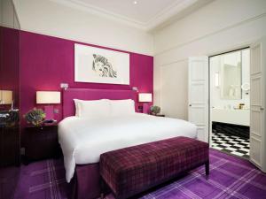 伦敦索菲特伦敦圣詹姆士酒店的卧室配有一张白色大床和紫色墙壁