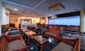 萨瓦伊马多普尔Spree Jungle Vilas Resort Ranthambore的餐厅配有沙发、桌子和大屏幕