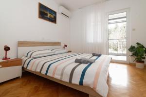诺维格勒伊斯特拉Apartments Jasna 3的一间卧室配有一张带条纹毯子的大床