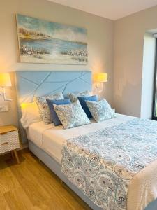 Villapedre埃尔皮纳尔酒店 的一间卧室配有一张带蓝色枕头的大床