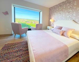 Villapedre埃尔皮纳尔酒店 的一间卧室设有一张大床和一个大窗户