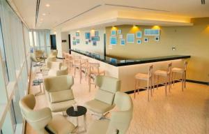 科伦坡Orion City Hotel的一间设有白色椅子和酒吧的等候室