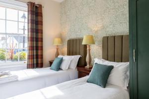 克兰利理查德盎斯洛酒店的带窗户的客房内的两张床
