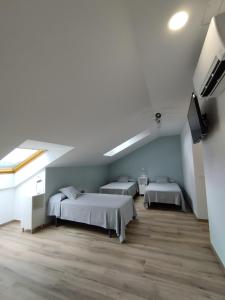 欧德鲁佐Pensión Residencial Platas的客房设有两张床和一台平面电视。