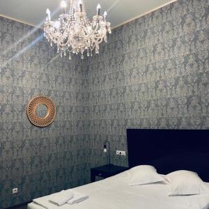克卢日-纳波卡Vila Vidalis的一间卧室配有一张床和一个吊灯
