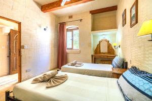 马萨尔福恩Ta Guljetta 4 bedroom Villa with private pool的一间卧室配有两张床和镜子