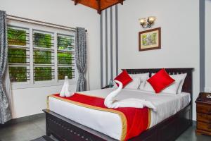 马迪凯里Clover Holiday Village的一间卧室配有一张带红色和白色枕头的大床