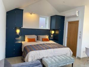 LlandogoTiny home, the Wye Valley, Clanna Cottage Llandogo的蓝色卧室配有带橙色枕头的大床