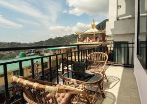 达兰萨拉Hotel Buddha's Abode的阳台配有桌椅。