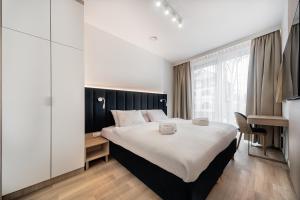 斯维诺乌伊希切Aurum Aparthotel - Nowe Apartamenty blisko Plaży - Neue Appartements in Strandnähe的一间卧室配有一张大床和一张书桌