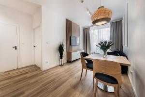 斯维诺乌伊希切Aurum Aparthotel - Nowe Apartamenty blisko Plaży - Neue Appartements in Strandnähe的用餐室以及带桌椅的起居室。