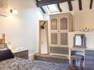 霍姆弗斯Weavers Cottage的一间卧室配有一张床、梳妆台和镜子