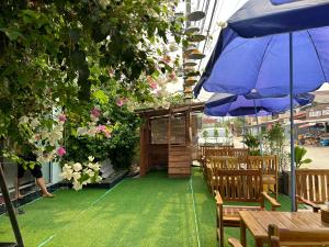 万荣Confetti Garden Resort的一个带蓝伞和木桌椅的庭院