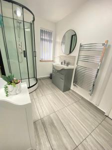 霍利Gatwick Studio的带淋浴、盥洗盆和镜子的浴室