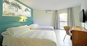 福恩吉罗拉Moon Dreams Fuengirola的酒店客房设有两张床、一张书桌和一个窗户。
